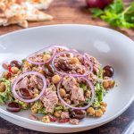 Insalata di ceci e tonno: una ricetta dietetica e veloce da preparare 1 Insalata di ceci e tonno servita in un piatto fondo, con cipolla e olive taggiasche