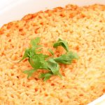 Riso al forno: il salva pasto comodo da preparare anche in anticipo 1 in primo piano in una pirofila di forma ovale del riso al forno guarnito con qualche foglia di basilico