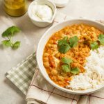 Dahl di lenticchie rosse: piatto unico speziato indiano 1 in primo piano su un piatto fondo bianco il dahl di lenticchie