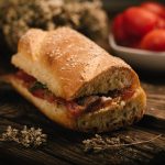 Pane cunzato: panino tipico siciliano, veloce da fare e ricco di gusto 1 in primo piano il pane cunzato siciliano condito con pomodori freschi, acciughe, origano e un filo d’olio extravergine