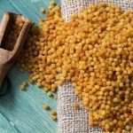 Fregola sarda: cos’è, come si cucina e i consigli per prepararla al meglio 1 in primo piano su un tavolo di legno, della fregola sarda tipica della Sardegna