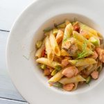 Pasta zucchine e salmone: un primo piatto sano e veloce 1 su base chiara una scodella bianca con della pasta zucchine e salmone