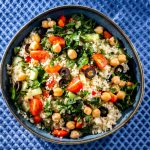 Insalata di cous cous e ceci: un piatto estivo e leggero 1 ricette con cous cous: su sfondo blu una ciotola con insalata di cous cous e ceci, pomodorini, olive nere e insalata
