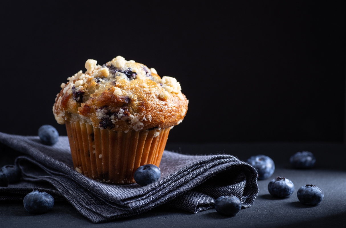 su tavolo tovagliolo con un muffin con mirtillo nero con mirtilli neri sparsi