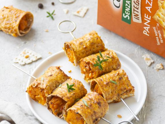 Involtini di zucca e pane azzimo al forno: ricetta e video ricetta di un piatto delizioso 7 piatto bianco con sopra due spiedini di involtini di zucca