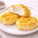Uova alla Jova: ricetta soffice al forno facile e veloce 1 In primo piano su un tavolo chiaro ci sono delle uova alla jova soffici con una spolverata di pepe sopra.