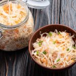 Verdure fermentate fatte in casa: la ricetta passo passo 1 su tavolo di legno barratolo di vetro con verdure fermentate e accanto ciottola di legno con 1 porzione di verdure