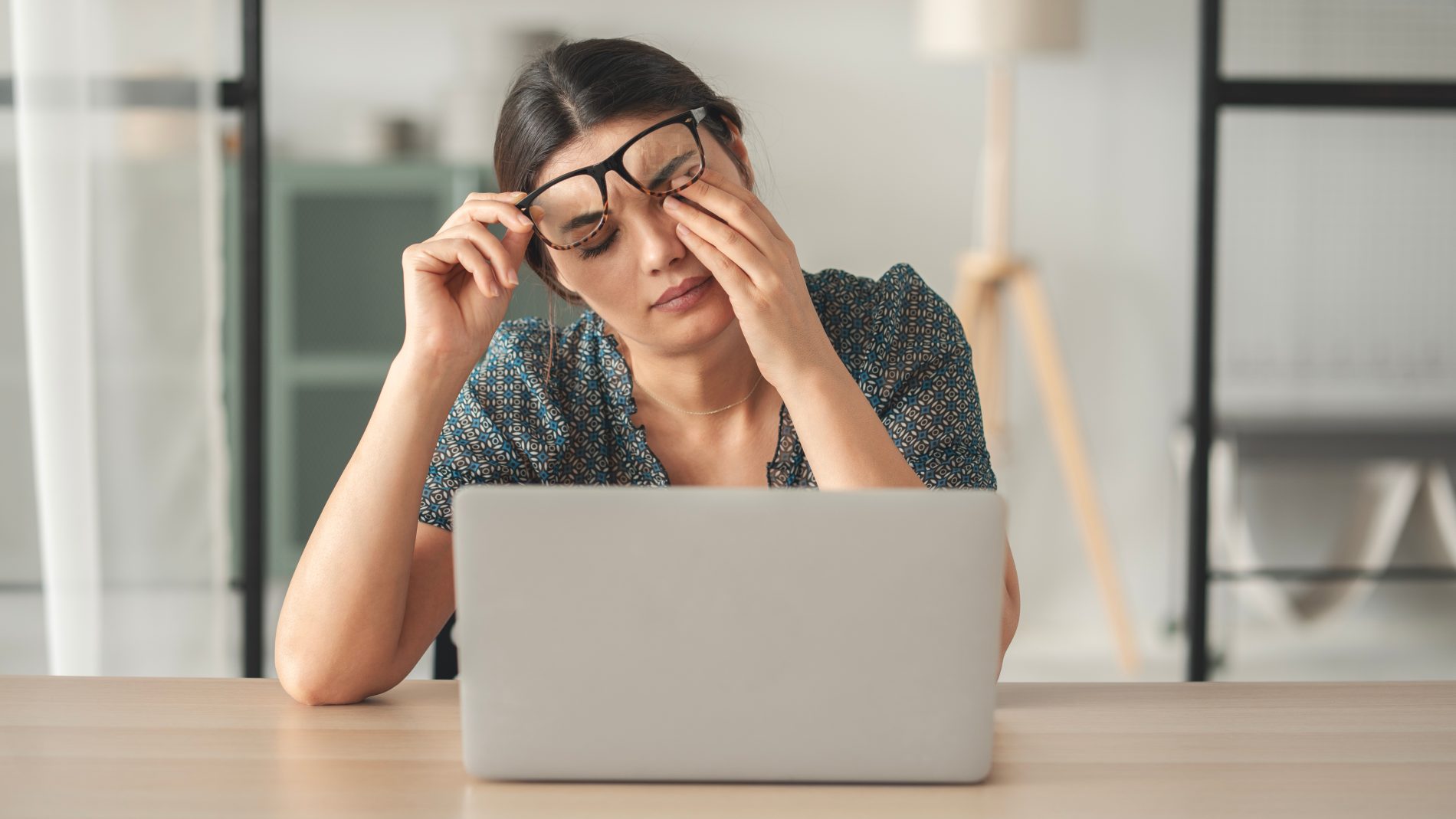 donna al computer che mostra segni di stanchezza e si strofina gli occhi chiedendosi se deve prendere integratori di vitanina B12