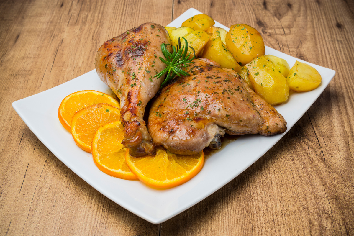 Carne di tacchino: che cos'è, valori nutrizionali, benefici della carne bianca, le migliori ricette 10 su piatto bianco due pezzi di tacchino al forno con patate e fette di arancia